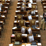 A member of the Sergeant at Arms, Jack Adams, places updated resolutions on the empty desks of House Representatives at the State Capitol on Sunday, May 26, 2013, in Austin, Texas. Members of the House of Representatives left the chamber to gather in their respective caucuses before returning to continue the 83rd Legislature. (AP Photo/Austin American-Statesman, Rodolfo Gonzalez)
