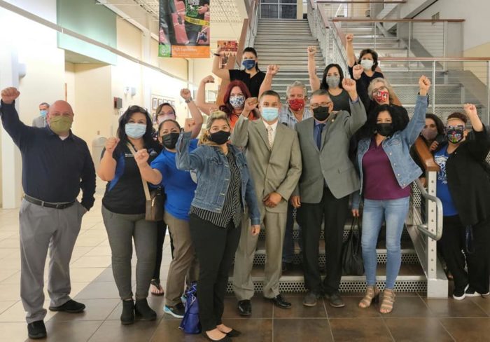 Group photo of Socorro school board members and Socorro A-F-T members and leaders. They are wearing face masks and raising their fists in solidarity.